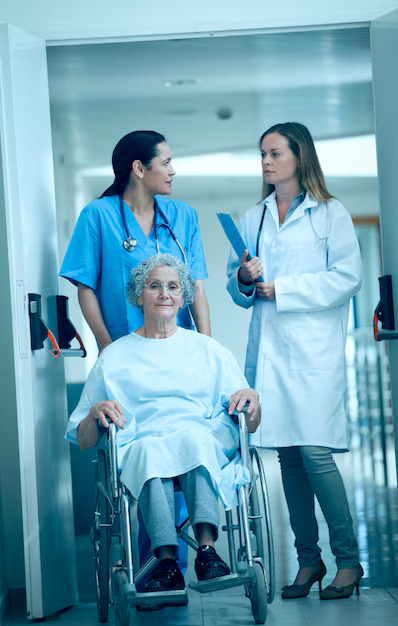 nurse-wheeling-senior-patient-patient-hallway_13339-288459